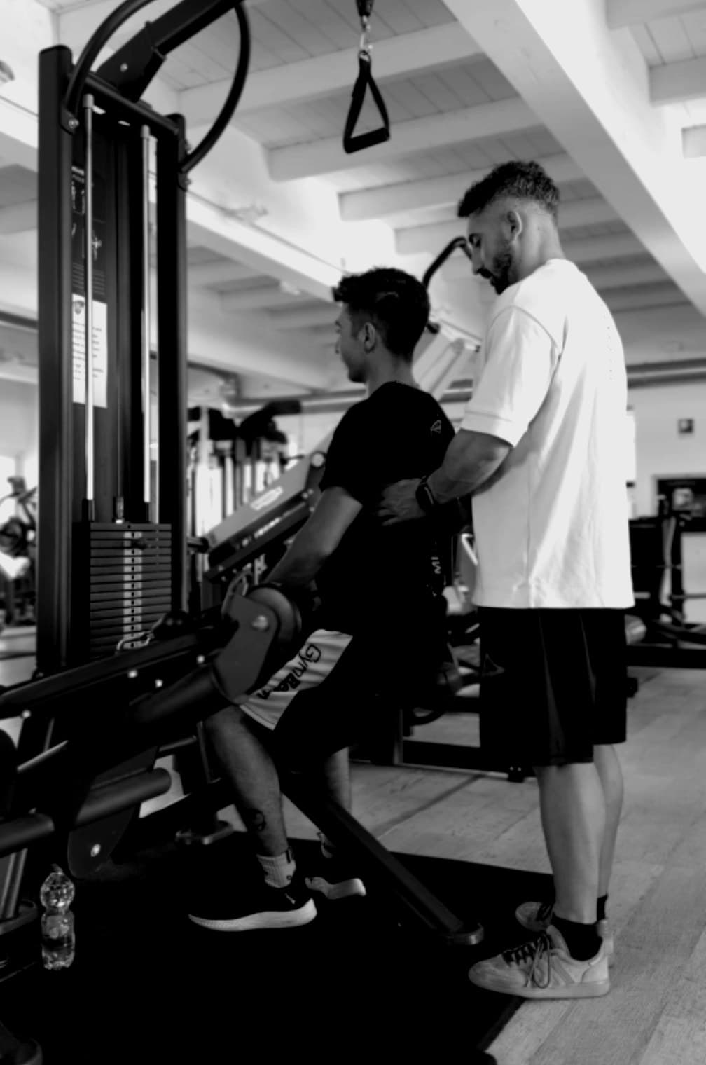Jacopo Di Mario segue da vicino un atleta durante un esercizio in palestra